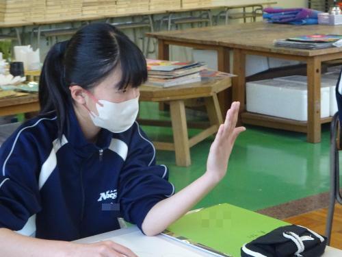 自分手を見つめデッサンする女子生徒