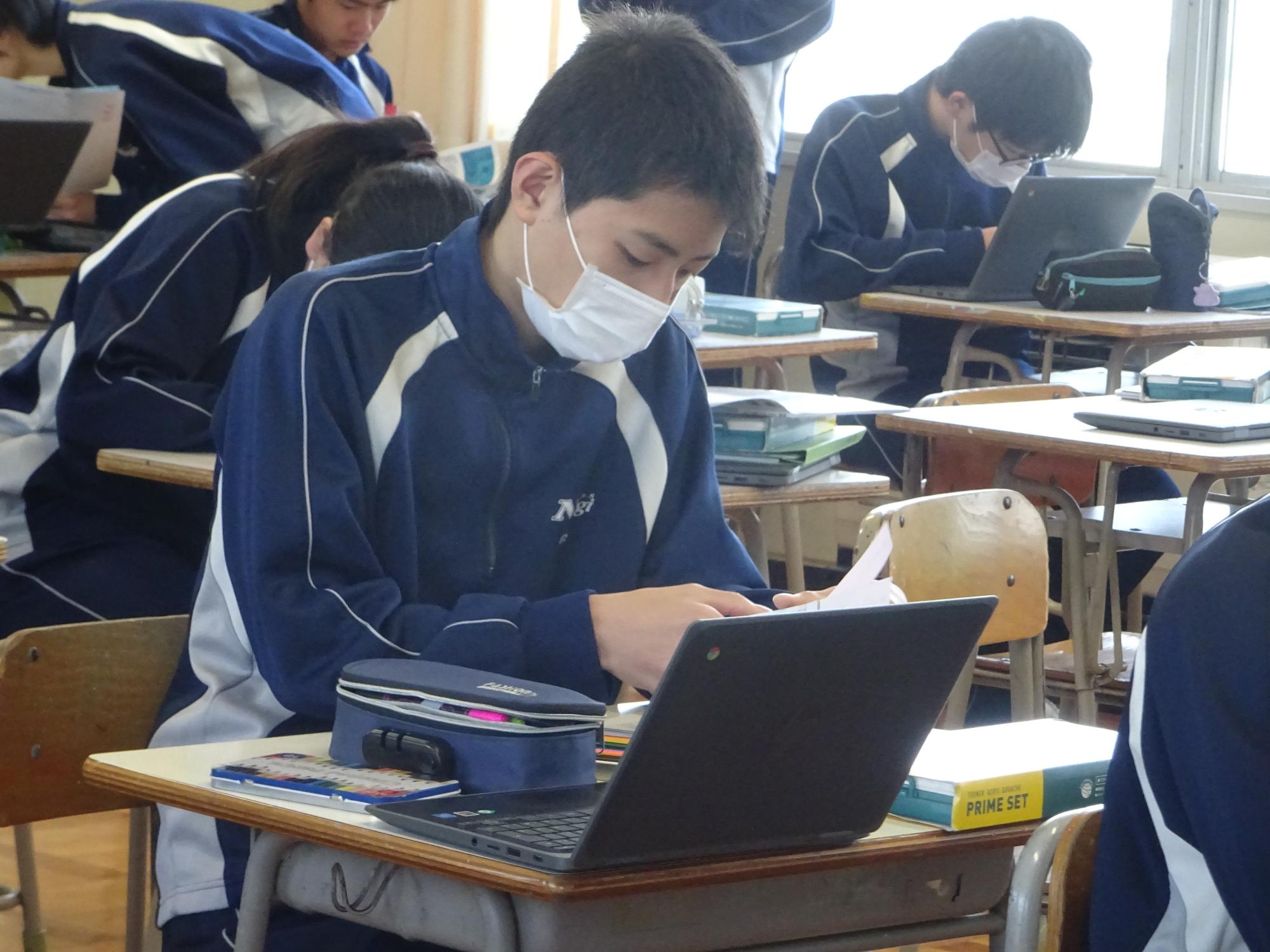 色見本を手に色を選ぶ男子生徒