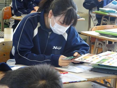 色見本を手に色を考える女子生徒