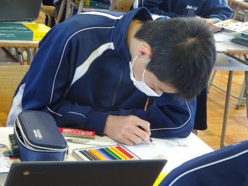 色鉛筆で下書きに着色する男子生徒