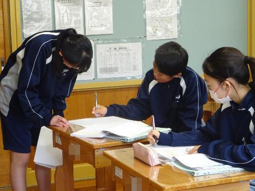 ノートを見ながら確認する男女
