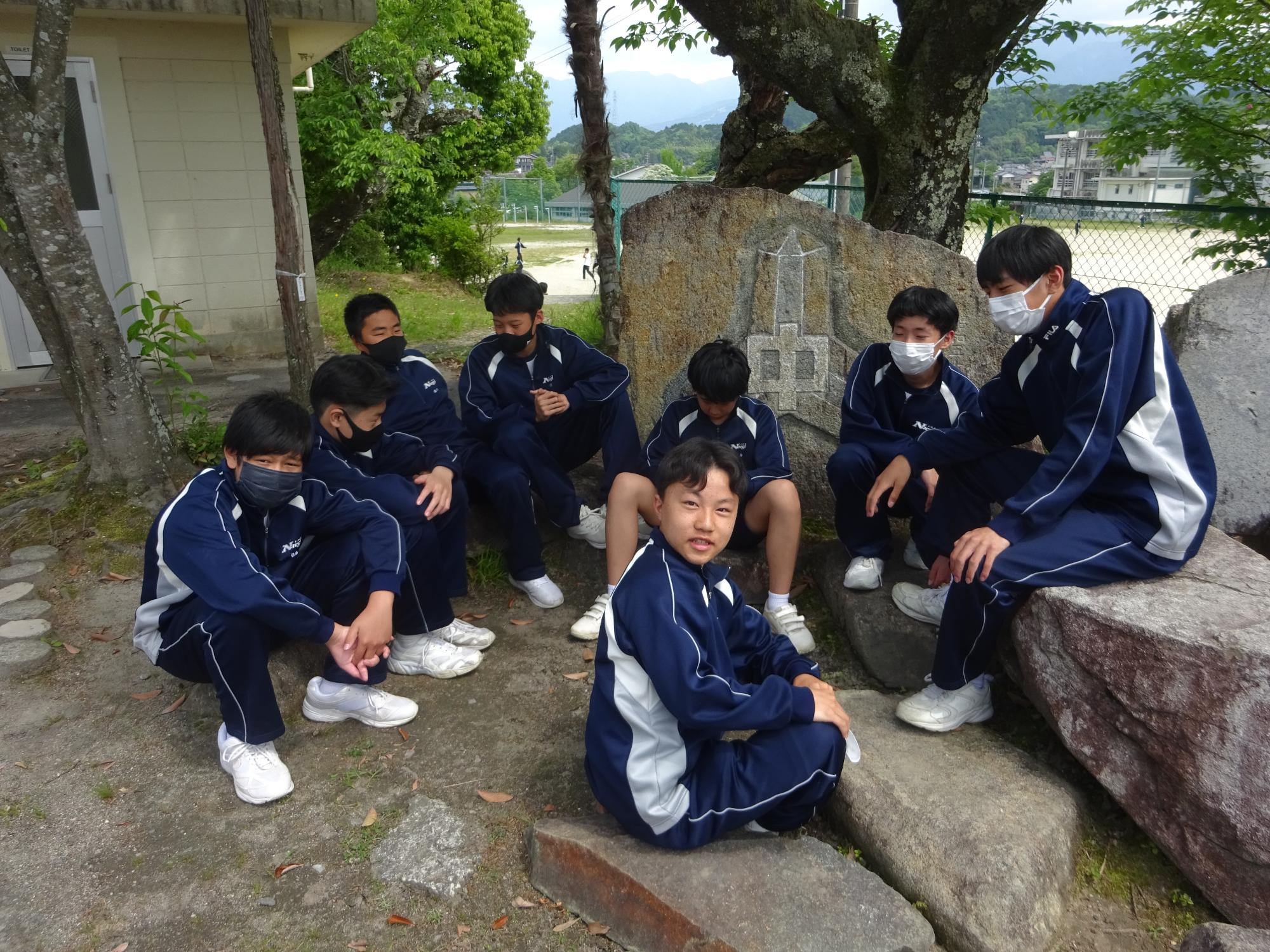車座になって集まって座っている男子生徒たち