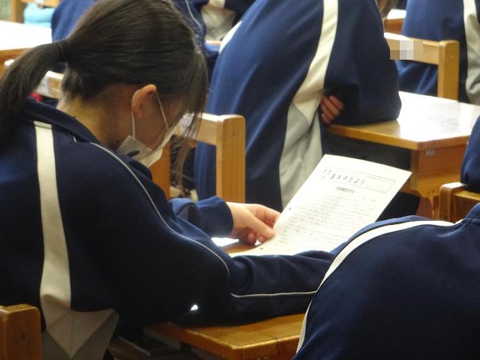 学校通信を読む女子生徒