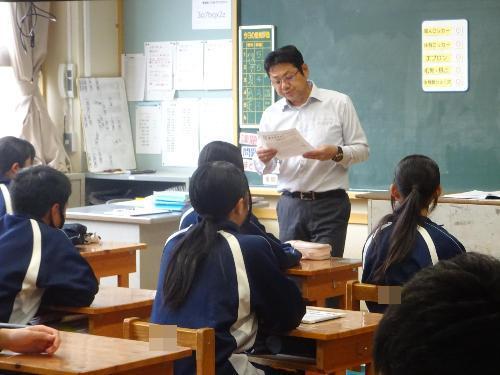学校通信を読み聞かせる職員