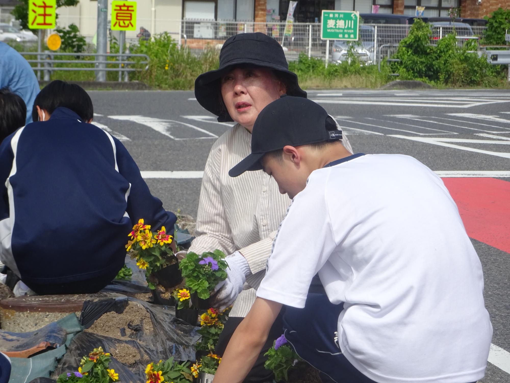 地域の方とお話しながら花を植える生徒