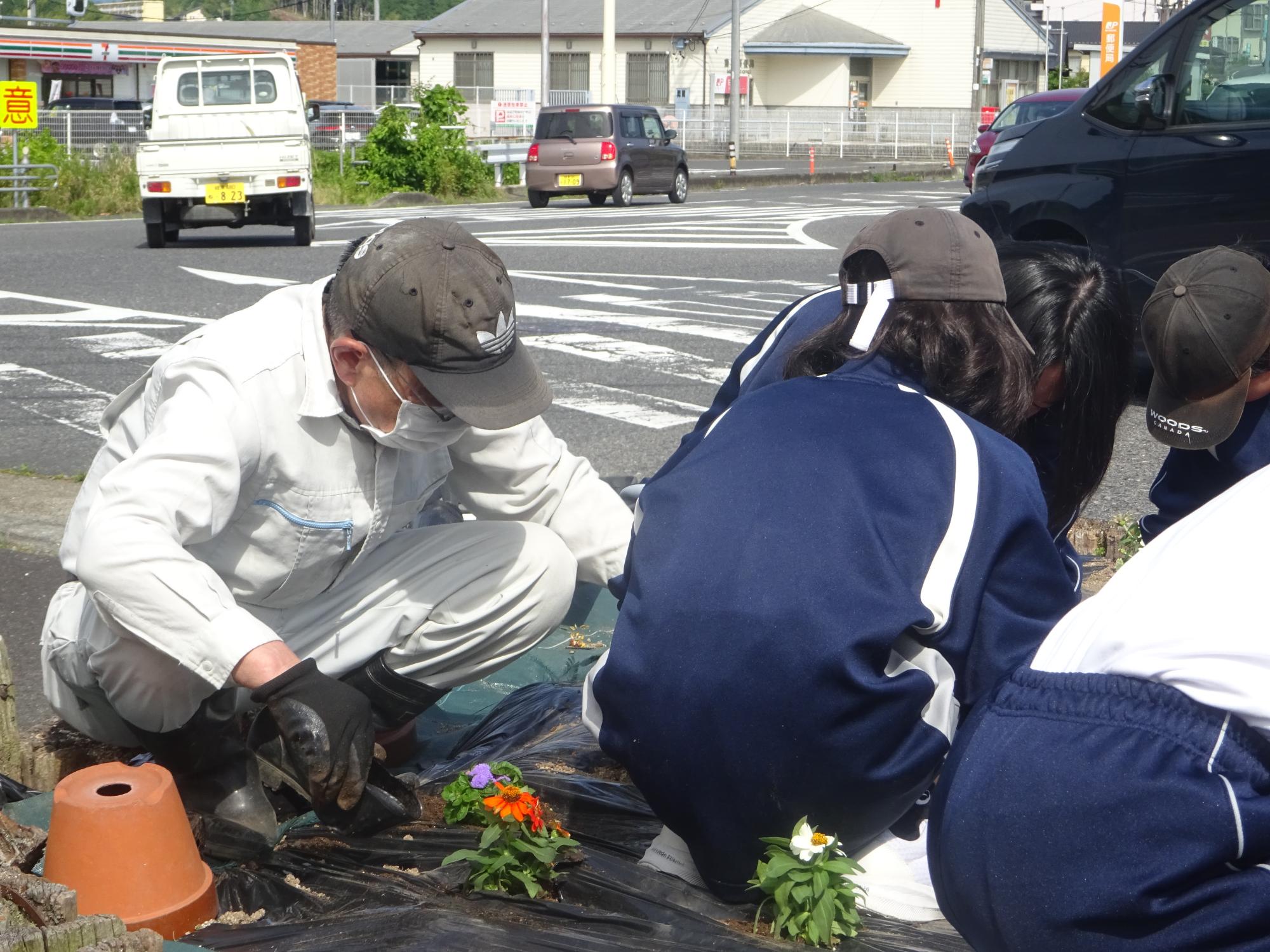 地域の方とお話しながら花を植える生徒