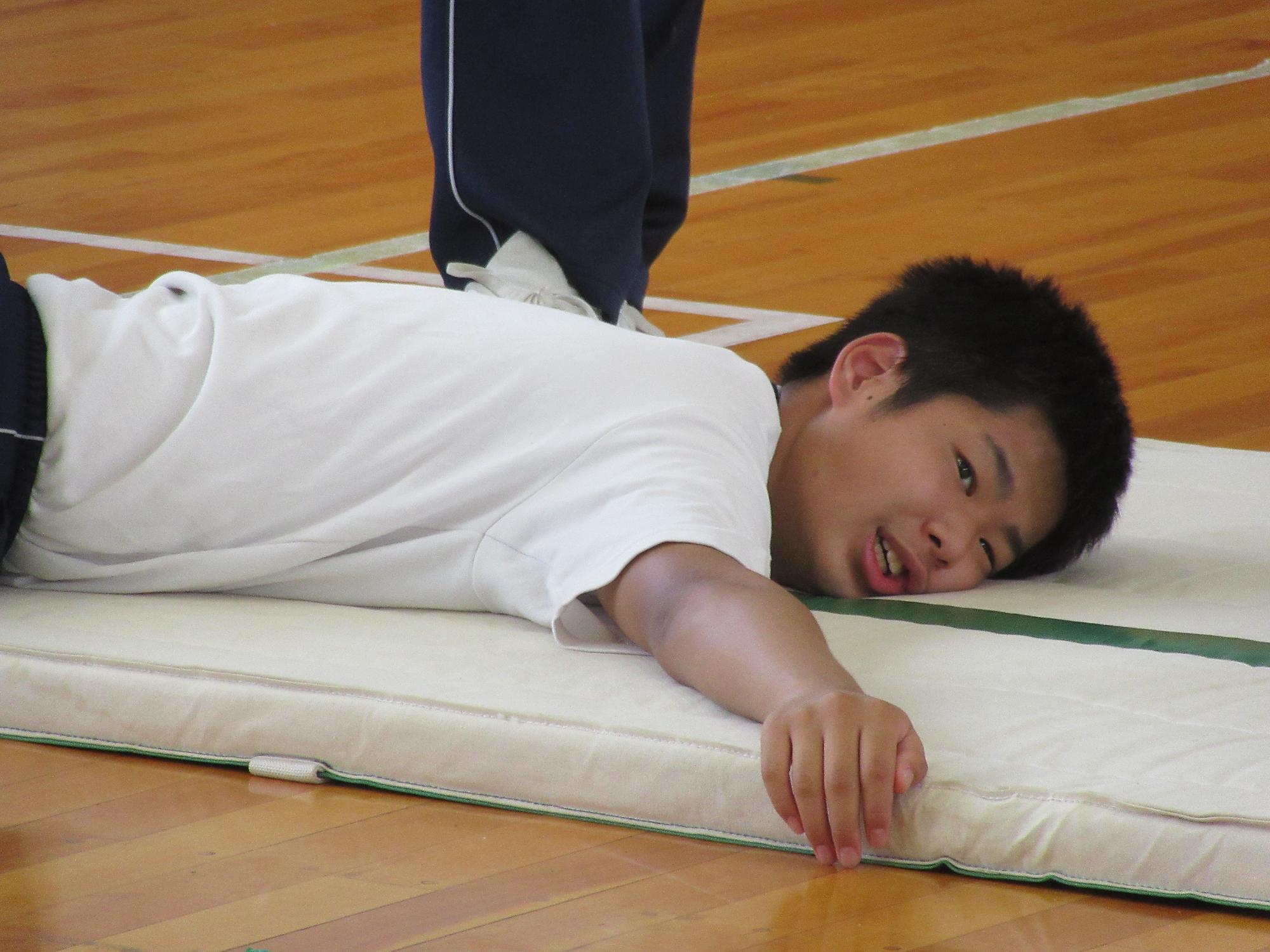 マットに抱き着く男子生徒