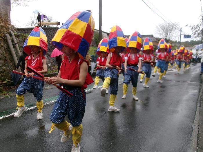 雨の中、沿道を練り歩きながら踊る中学生