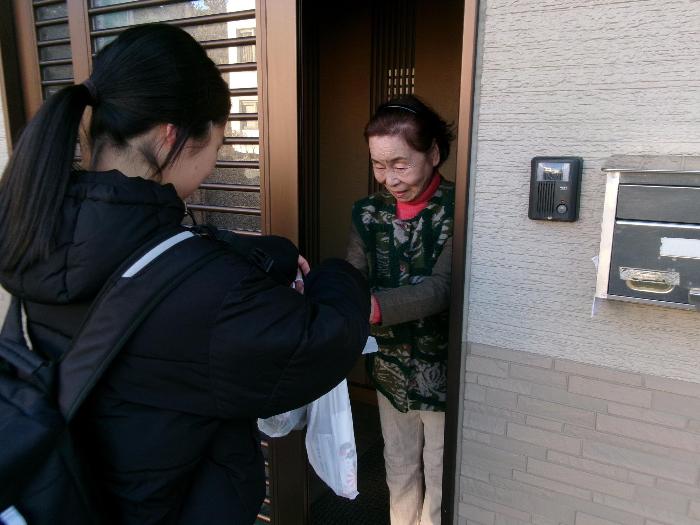 殿塚地区でお節を配付する生徒たち