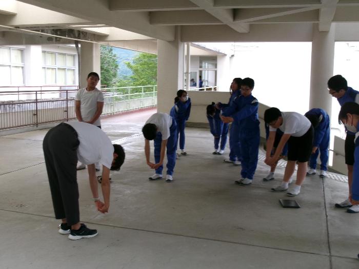 コミュニティホールでストレッチをする生徒たち