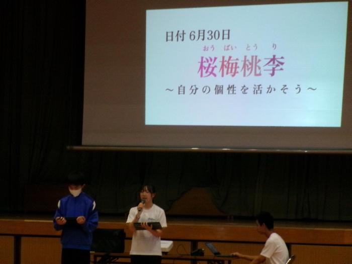 全校帰りの会で合唱大会スローガンを確認する文化委員