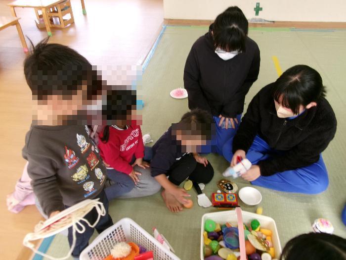 未満児クラスでおままごとをする園児と3年生