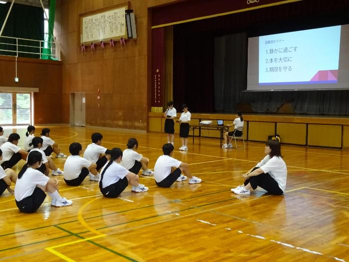 全校帰りの会の中で図書館マナーについて話す図書委員の生徒