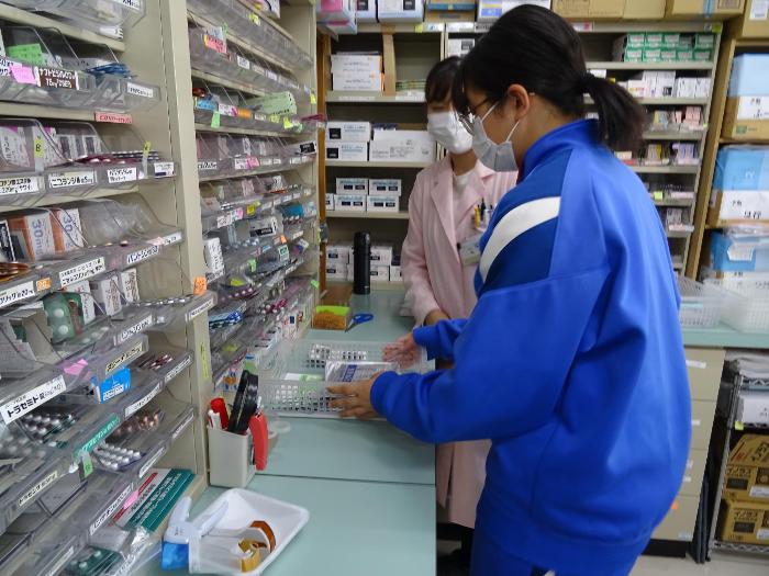 薬局で仕事をする生徒