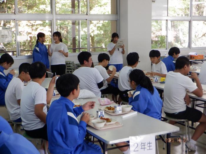全校生徒の前で給食の献立を紹介する生徒たち