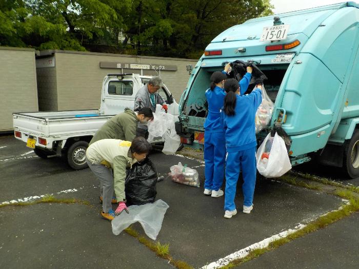 アルミ缶をパッカー車に積み込む生徒と保護者