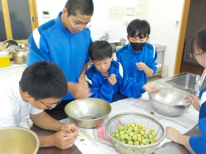 室内で梅のへたを除去する中学生たち