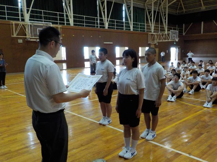 表彰で賞状を手渡す校長と受け取る生徒たち
