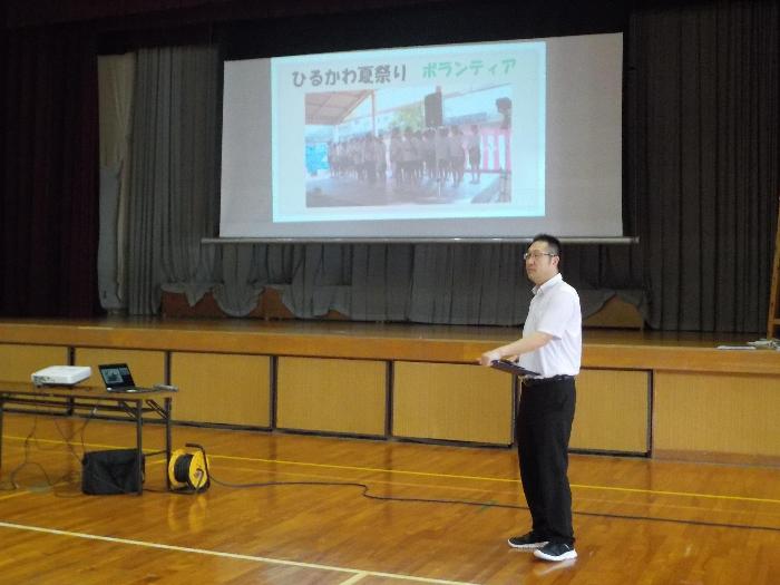 集会の中で夏休み中の生徒の活躍を紹介する校長
