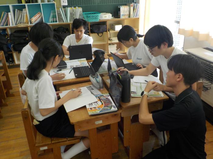 新しいタブレットを使ってグループ学習をする中学生