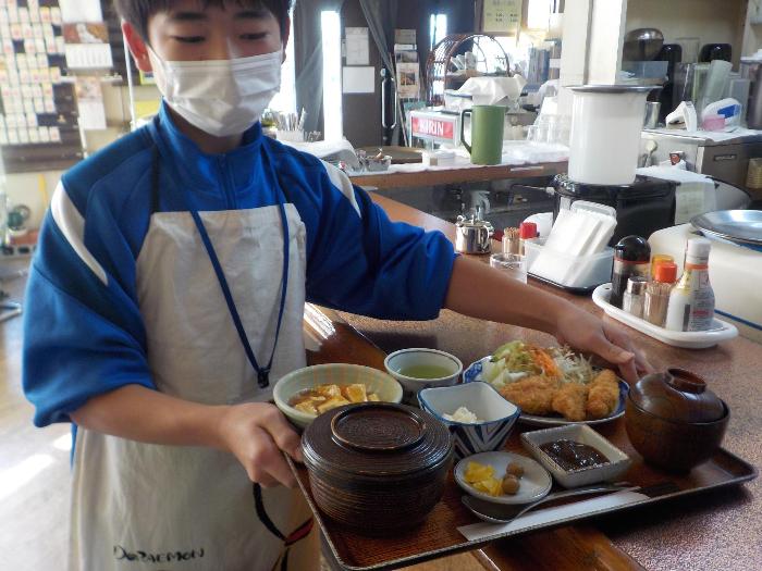飲食店で仕事をする生徒