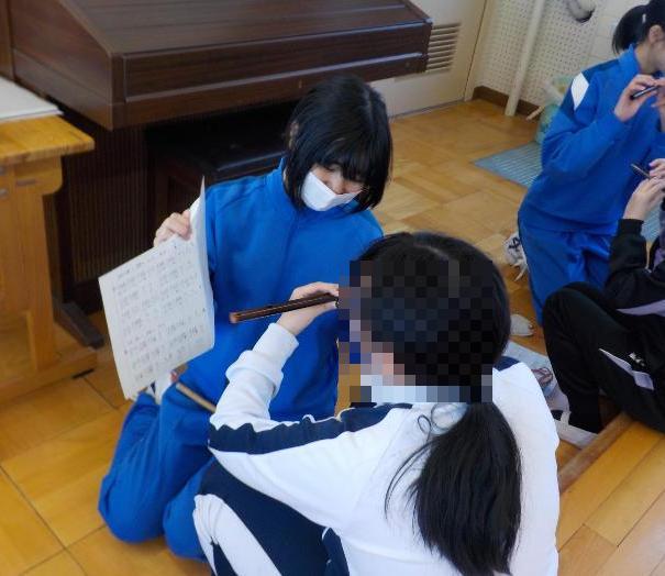 小学生にお囃子を教える中学生