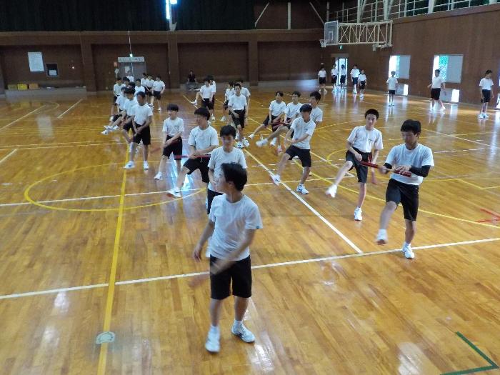 体育館で両団一緒になって杵振りを練習する中学生