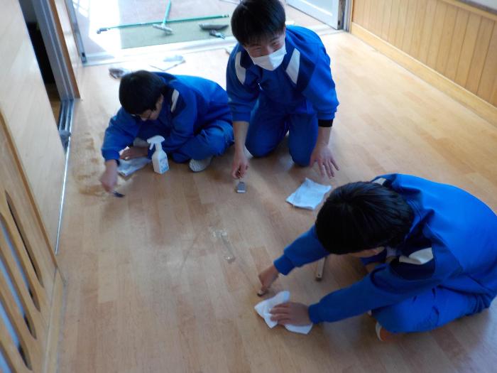 細かな汚れをヘラを使ってきれいにする中学生