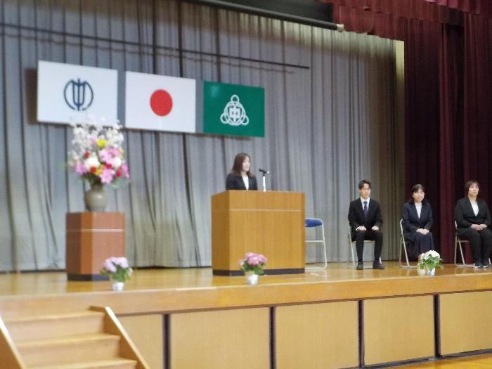 着任式の中で壇上で挨拶をする転入職員