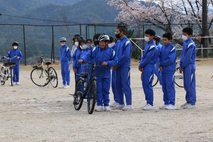 交通安全教室で交差点で自転車を降りて左右確認をする代表生徒