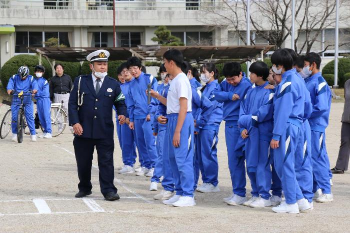 横断歩道でのマナーについて警察署の方の説明をうける中学生