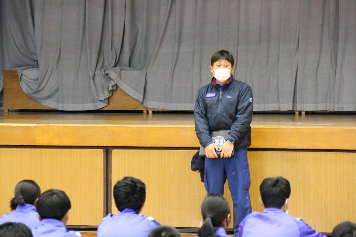 体育館で全校生徒に話をする講師の消防署員