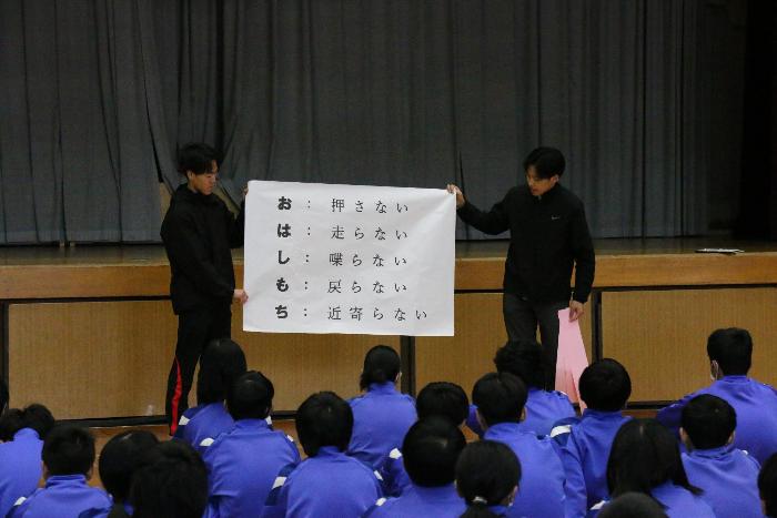 全校生徒の前で「おはしもち」について説明する担当職員