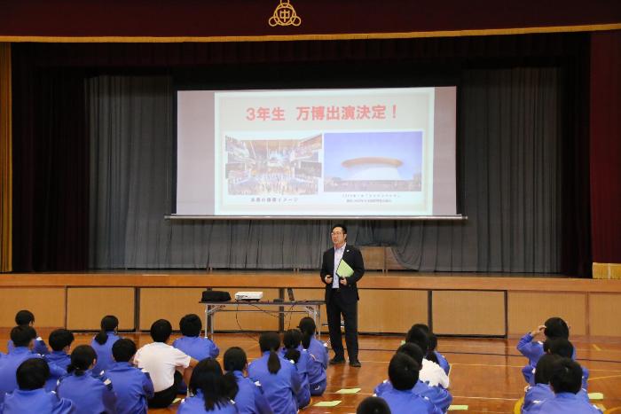 生徒総会の中で3年生が大阪・関西万博に出演することを発表する校長