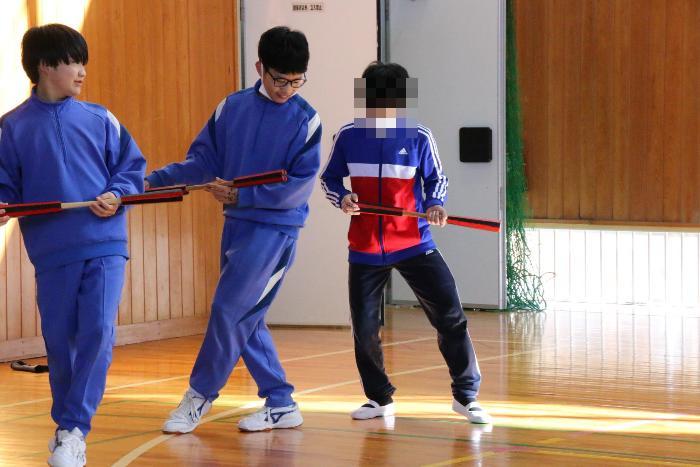小学生に杵振りを教える中学生