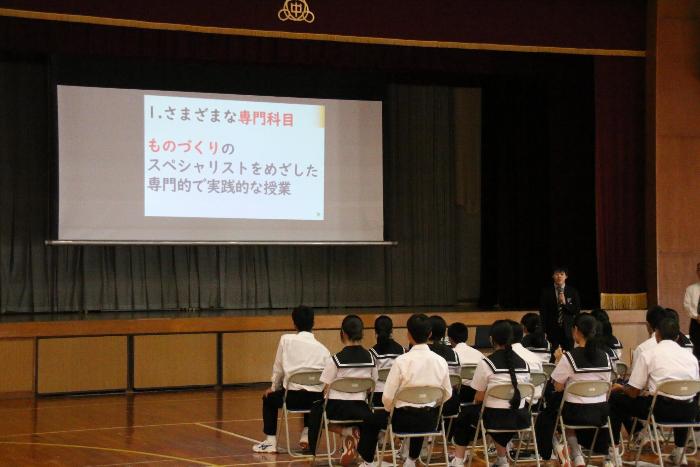 体育館で高校の先生の話をきく3年生