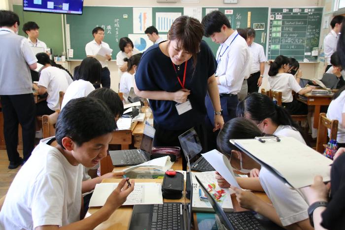 市の教科研究会で仲間と積極的に交流する3年生と見守る教師