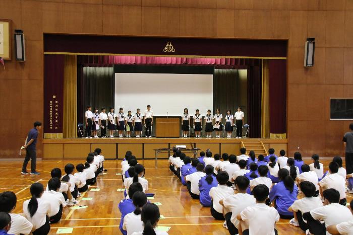 ステージに登壇した立候補者14名と静かに整列する全校生徒