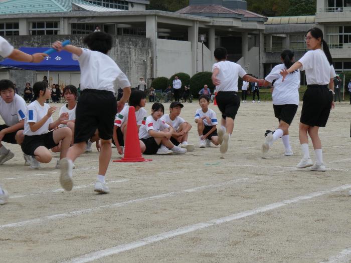 全校種目の全校リレーで、バトンを受け取り走り出す生徒
