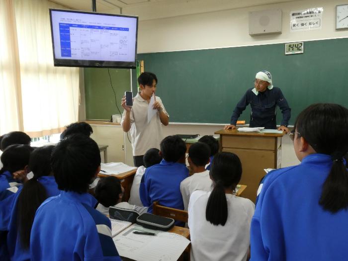 災害電話の使い方について実演して説明する担任
