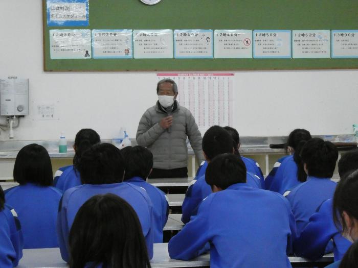 全校生徒の前で杵振り花馬祭りについて話をする西山さん