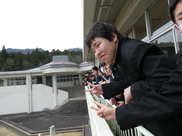 ベランダから卒業生を見送る在校生