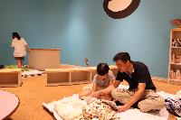 図書館に布団を敷いて読み聞かせをする親子2