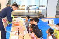 図工の講師の話を聞く小学生達