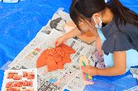 粘土で魚を作る女の子