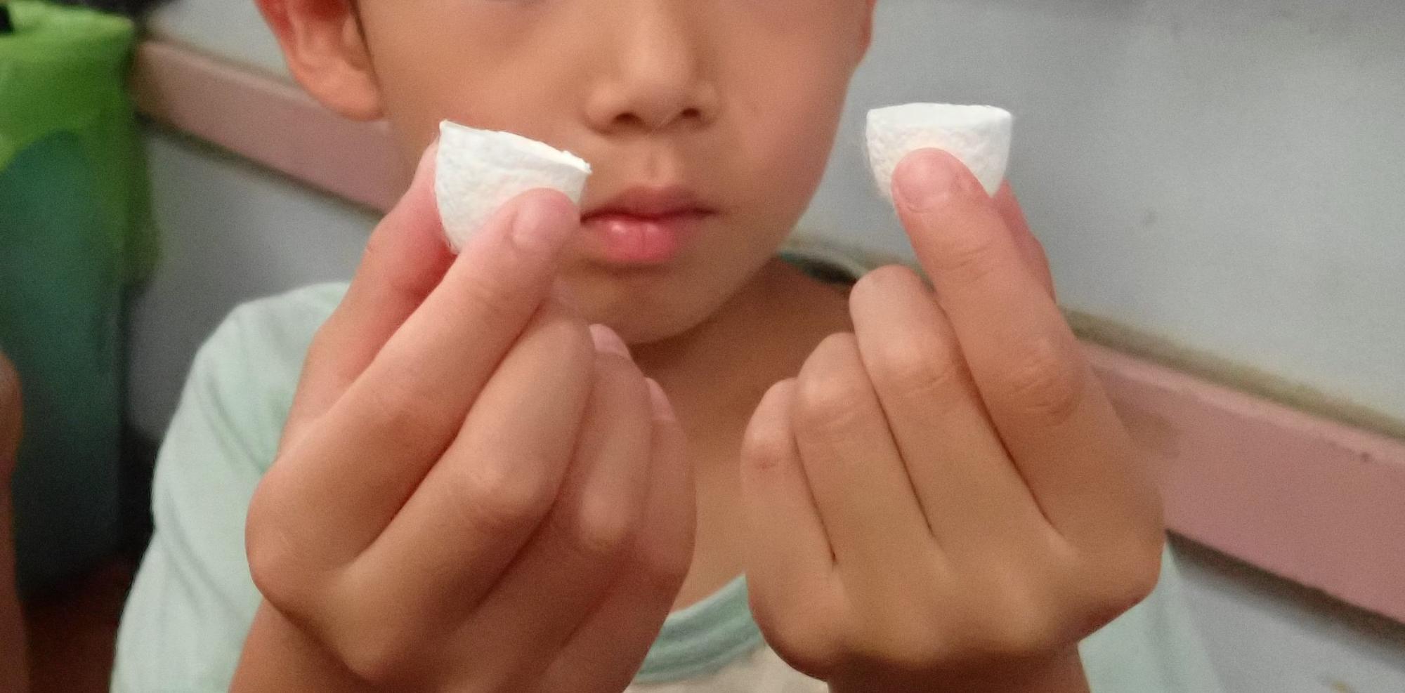 子供が切った繭玉をみている