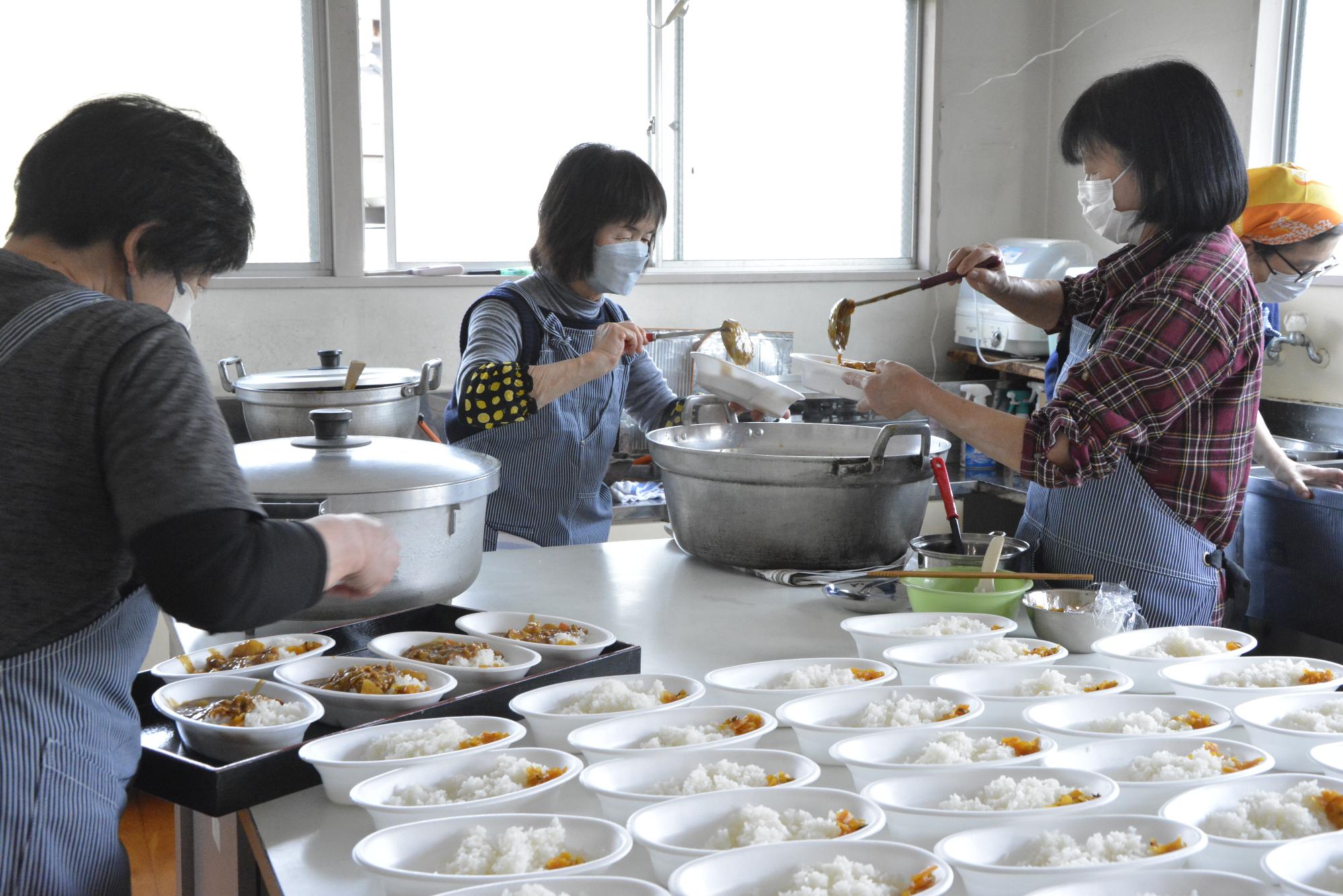 カレーライスを調理する地域のボランティア