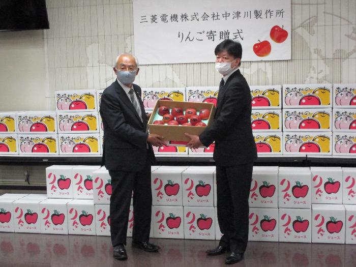 三菱電機株式会社中津川製作所所長小谷総務部長から市長にりんご等を寄贈する様子