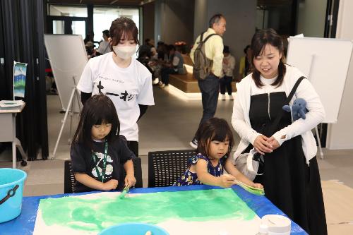 子供たちが和紙に色つけしてオブジェを作っている様子