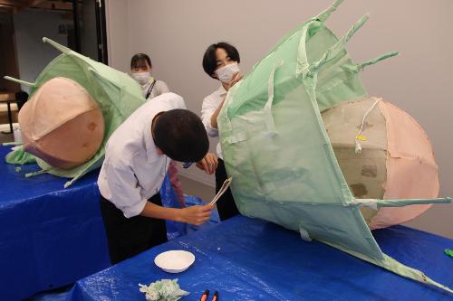 高校生がオブジェの和紙貼付けをしている様子
